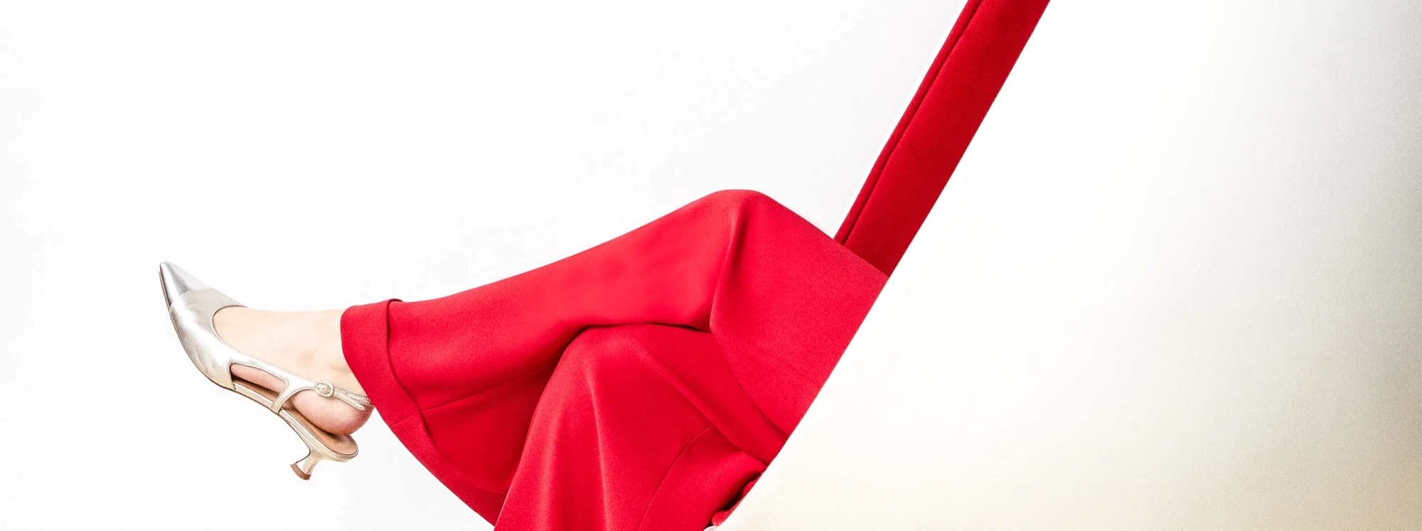 Femme en costume rouge installée dans un fauteuil
